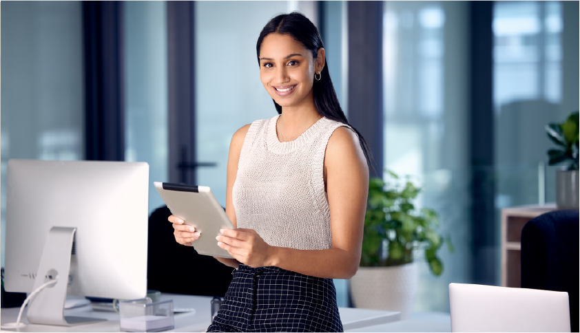 A young woman holding a tablet and smiling at the camera